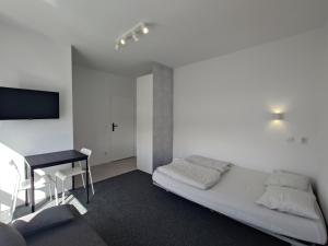a white room with a bed and a desk at Marynarska 57 in Darlowko