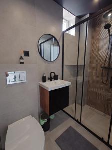 a bathroom with a toilet and a sink and a mirror at Marynarska 57 in Darlowko +25 photos