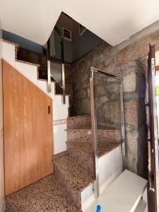 ein Bad mit einer Dusche und einer Treppe in einem Zimmer in der Unterkunft Casita rural acogedora in Combarro