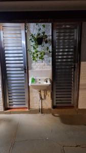 a bathroom with a sink with plants on the wall at Pousada Florada na Serra - Apto 1 in Campos do Jordão