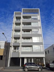 een wit gebouw met een auto ervoor geparkeerd bij Departamento Venthos in Puerto Madryn