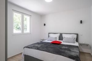 a bedroom with a bed with a red pillow on it at Apartments dida Ante in Blato