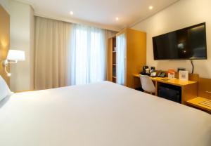 a hotel room with a large bed and a desk at Abba Rambla Hotel in Barcelona