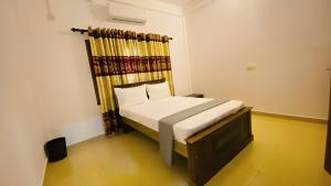 een kleine slaapkamer met een bed in een kamer bij Columbus villa in Jaffna +7 foto's