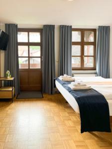 a bedroom with two beds with blue curtains at Villa Fantasia Budget Boutique Hotel in Füssen