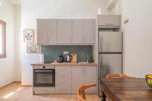 a kitchen with white cabinets and a refrigerator at Redvalley villa in Pylos