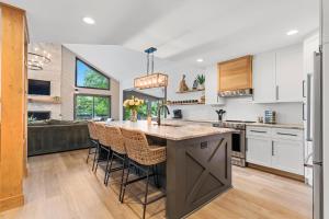 a kitchen with a large island with bar stools at Niblick on Norman w/Heated Pool & Optional Boat Rental in Cornelius