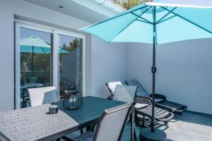 a table with chairs and an umbrella on a patio at Apartments dida Ante in Blato