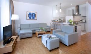 a living room with a couch and a table and a kitchen at Rheinhof by Gerda Good Living - Digital Access in Meerbusch +35 photos