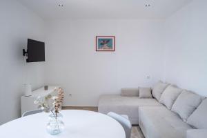 a white living room with a couch and a table at Apartments dida Ante in Blato