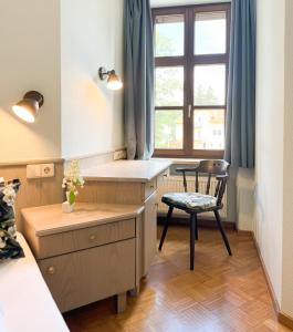 a kitchen with a chair and a table and a window at Villa Fantasia Budget Boutique Hotel in Füssen