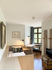 a room with a bed and a desk and a television at Villa Fantasia Budget Boutique Hotel in Füssen