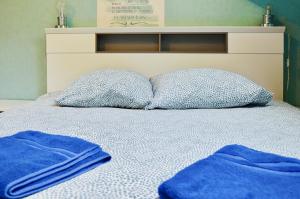 ein Bett mit zwei Kissen und blauen Handtüchern darauf in der Unterkunft Beautiful Cottage Disneyland Paris - Rentaway BnB in Chessy + 54 Fotos