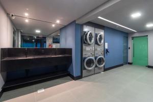 a laundry room with three washing machines and a sink at Loft próximo a Vila Germânica e FURB com vaga. in Blumenau