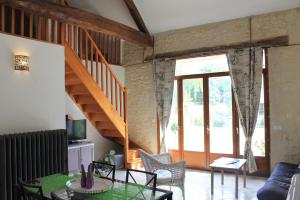 a living room with a table and a staircase at Gîte de La Huaudière in Mosnes