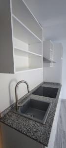 a kitchen counter with a sink and empty shelves at Holidays Domus Papokkio in Igualada