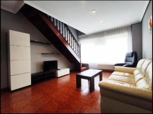 a living room with a couch and a staircase at ApartamentoDJ in Suances