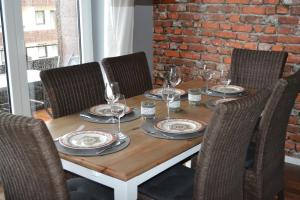 a wooden table with wine glasses and plates on it at Ferienwohnung Hampton in Braunlage