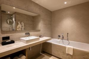 a bathroom with a sink and a bath tub at Van der Valk Hotel Emmen in Nieuw-Amsterdam