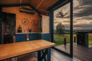 a kitchen with a table and a large window at TinyHouse Louis in Světlík