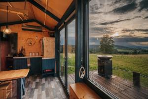 a kitchen with a large window with a view of a field at TinyHouse Louis in Světlík
