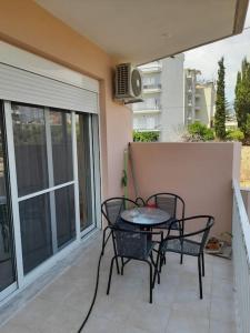 a patio with a table and chairs on a balcony at Ομορφο νεο στουντιο στην πολη της Ιτεας in Itea