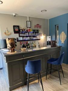 a bar with two blue chairs and a counter at Hotel Best Western La Mare Ô Poissons in Ouistreham