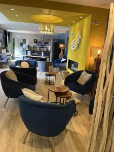 a living room with couches and chairs and tables at Hotel Best Western La Mare Ô Poissons in Ouistreham