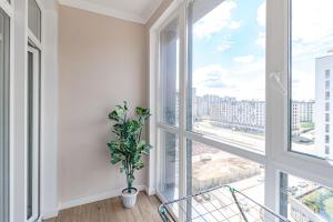 a room with a window and a potted plant at Tokyo, a Residential Complex in Astana