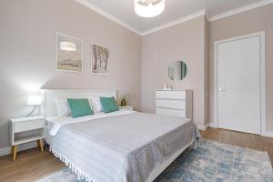 a white bedroom with a bed and a blue rug at Tokyo, a Residential Complex in Astana