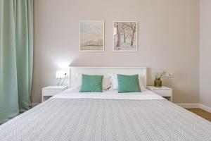a bedroom with a large white bed with green pillows at Tokyo, a Residential Complex in Astana