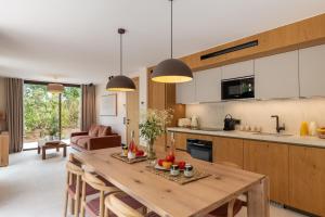 a kitchen and living room with a wooden table at Les Maisons Du Sud in Saint-Tropez