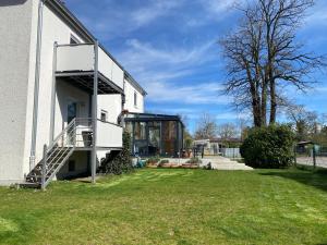 ein weißes Gebäude mit einer Treppe neben einem Hof in der Unterkunft Ferienwohnung Lechfeld in Untermeitingen