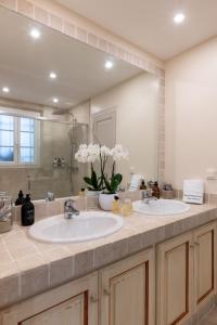 a bathroom with two sinks and a large mirror at Les Maisons Du Sud in Saint-Tropez