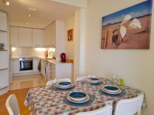 a dining room table with chairs and a kitchen at Apartamento Lliris Atico in L'Estartit