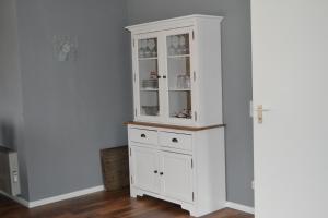 a white hutch in a corner of a room at Ferienwohnung Hampton in Braunlage