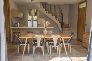 a dining room with a wooden table and chairs at Les Maisons Du Sud in Saint-Tropez