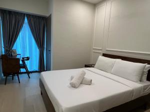 a hotel room with a bed with a towel on it at Eaton Residence Suites KLCC in Kuala Lumpur