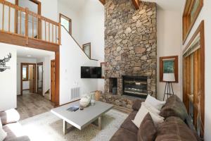 een woonkamer met een stenen open haard bij Luxury Mountaintop Family Retreat in Lyndhurst