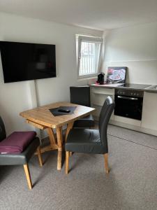 a small room with a wooden table and chairs at Ferien- bzw. Zeitwohnen Burglengenfeld » Apartment 2 in Burglengenfeld