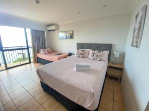 a bedroom with a large bed and a balcony at Aquarius 703 in Townsville +4 photos