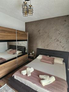 乌尔齐尼Apartments Ishmi in center of Ulcinj的一间卧室，有两张床，床上有毛巾