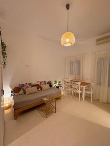 a living room with a couch and a table at Walk The View Apartment with village view in Chora in Ios Chora