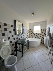 a bathroom with a tub and a toilet and a sink at Nature View Villa in Podu Cheii +25 photos