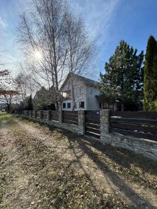 a fence in front of a house on a dirt road at Nature View Villa in Podu Cheii