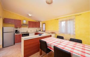 cocina con mesa y cocina con paredes amarillas en Beautiful Apartment In Sisan With Wifi, en Šišan
