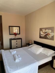 a bedroom with a white bed with towels on it at Sunrise house apartments in Ulcinj