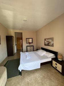 a bedroom with a large white bed and a couch at Sunrise house apartments in Ulcinj