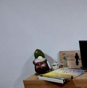 een speelgoedkikker die op een tafel naast een boek zit bij Domu Mea in Quartu SantʼElena