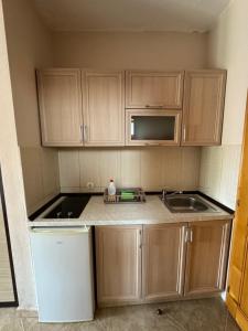 a small kitchen with wooden cabinets and a sink at Sunrise house apartments in Ulcinj